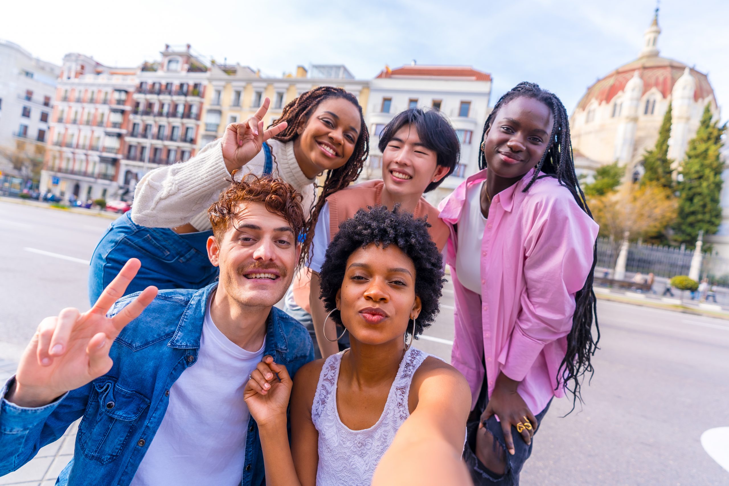 Gen Z Students of multiple ethnicities taking a selfie while partnering with James Carpenter Travel